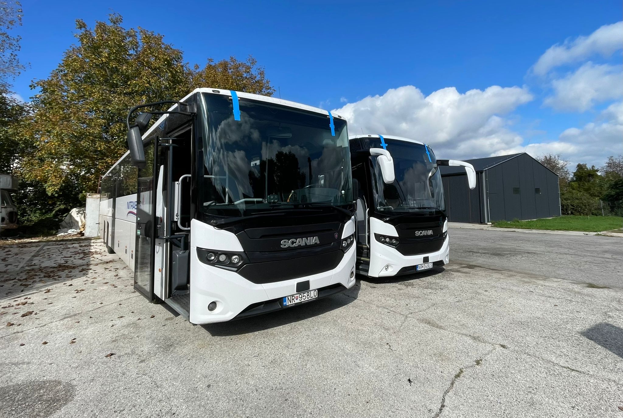Coach windscreens — publisher archive Two Scania coaches with large front windscreens and blue tape along the upper glazing edges.