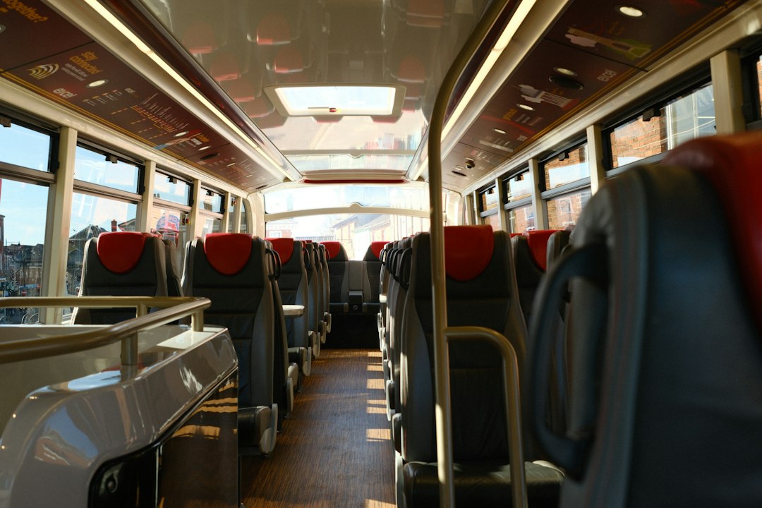 Illustrative bus interior with windows — Riley Brockett / Unsplash Sunlight and passenger windows inside a bus, illustrative photograph; does not depict Amplisky product.