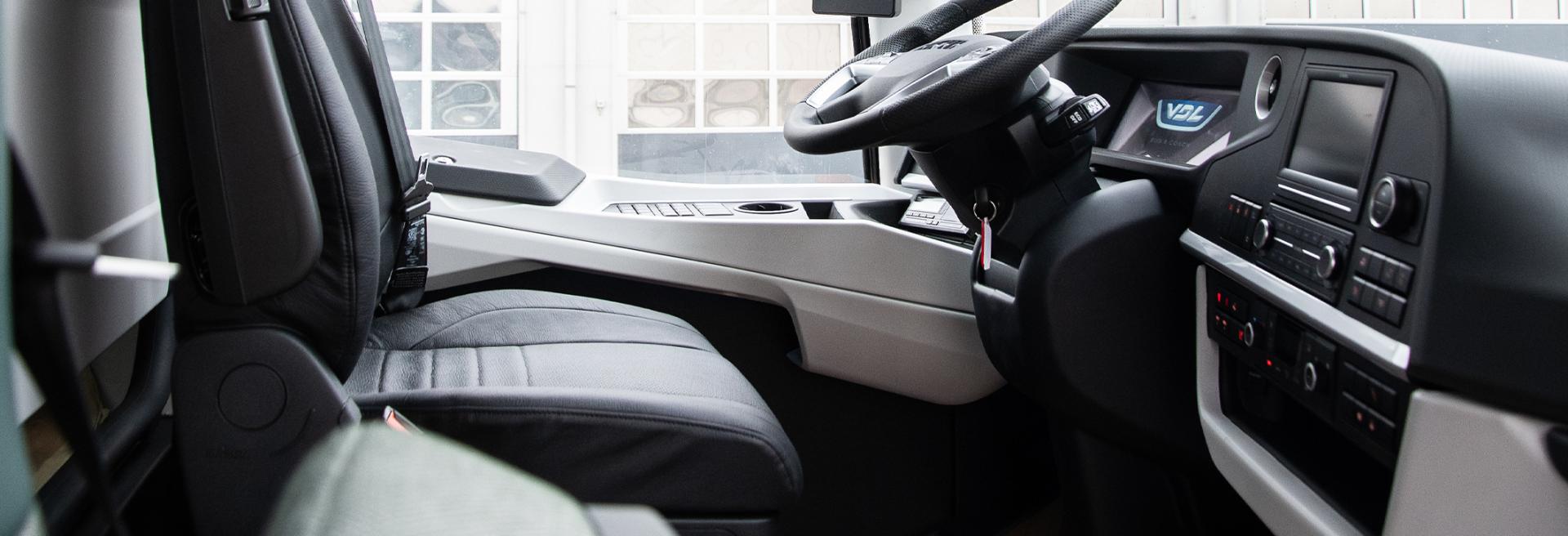 VDL Futura driver's seat and dashboard beside the driver's side window.